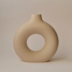 A brown "O" shaped vase with a hollow middle.
