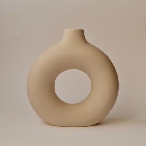 A brown "O" shaped vase with a hollow middle.