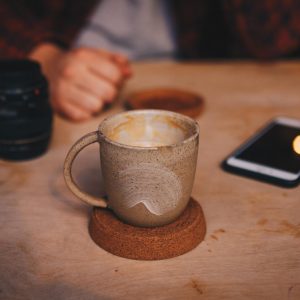 A handmade, wheel-thrown mug with an Earthy glaze and pale white smear.