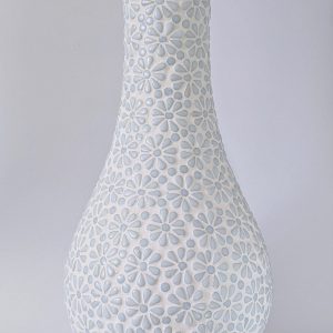 A tall, white vase with flower imprints.