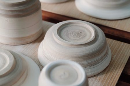 Several wheel-thrown bowls drying.